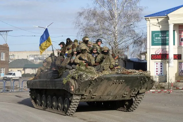 Ukrainian soldiers ride a tank through the town of Trostsyanets, some 400 km eastern of capital Kyiv, Ukraine, Monday, March 28, 2022. The more than month-old war has killed thousands and driven more than 10 million Ukrainians from their homes – including almost 4 million from their country. (Photo by Efrem Lukatsky/AP Photo)