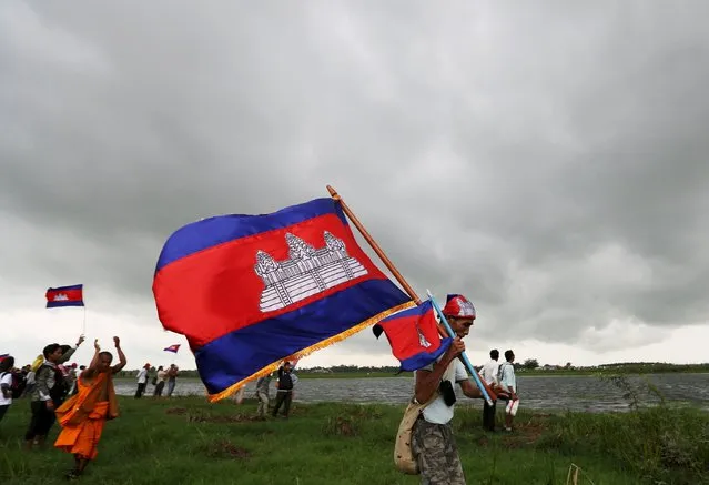 Supporters of the Cambodian National Rescue Party (CNRP), carrying the Cambodian national flag, arrive at a Cambodia-Vietnam border during a visit led by the party in Svay Rieng province July 19, 2015. (Photo by Samrang Pring/Reuters)