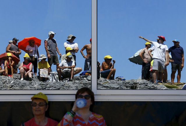Supporters are reflected in a window at the finish line in La Pierre Saint Martin during the 10th stage of the 102nd Tour de France cycling race from Tarbes to La Pierre-Saint-Martin, France, July 14, 2015. (Photo by Stefano Rellandini/Reuters)