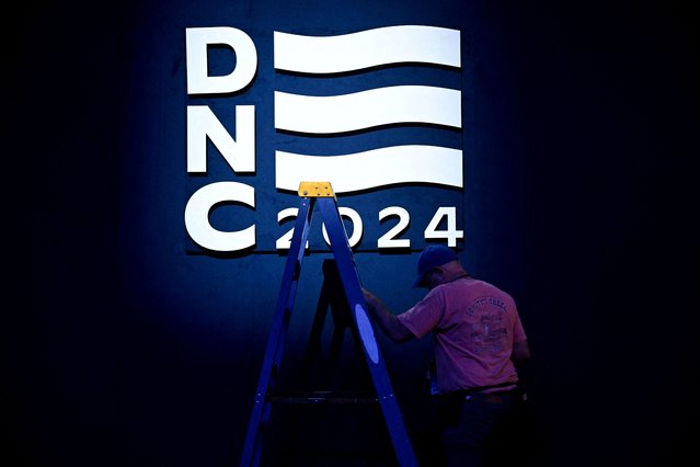 A worker holds a ladder next to the DNC sign at the United Center, the host venue of the Democratic National Convention (DNC) in Chicago, Illinois on August 18, 2024. (Photo by Vincent Alban/Reuters)