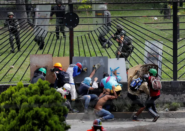 Demonstrators clash with riot security forces at the fence of an air base while rallying against Venezuela's President Nicolas Maduro in Caracas, Venezuela, May 31, 2017. (Photo by Marco Bello/Reuters)