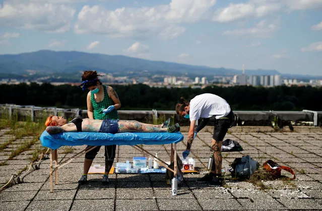 Professional body artist Dino Helvida (R), 27, and his girlfriend Zorana Unkovic (C), 27, prepare Kaitlin, 28, from the United States for body suspension in Zagreb, Croatia June 7, 2016. (Photo by Antonio Bronic/Reuters)