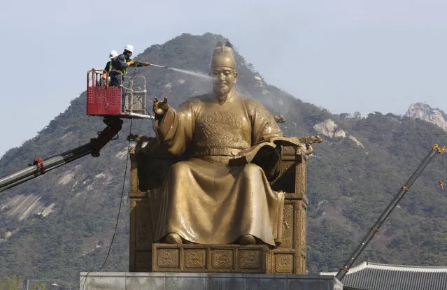 A worker sprays water onto the statue of King Sejong for a spring cleaning at the Gwanghwamun Plaza in Seoul, South Korea, Monday, April 10, 2017. King Sejong, the fourth king of the Joseon Dynasty (1392-1910), created the Korean alphabet, Hangul, in 1446. (Photo by Ahn Young-joon/AP Photo)