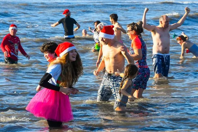 Swimmers take part in the annual Christmas Day swim in Charmouth, Dorset, England on December 25, 2019. (Photo by Alamy Live News)
