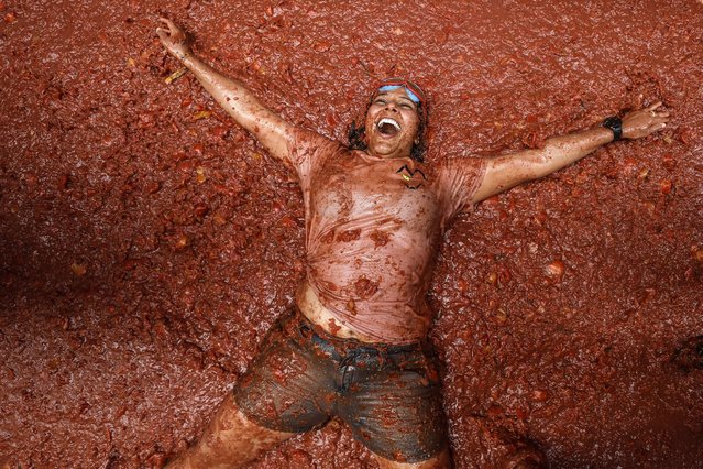 People attend the traditional Tomatina Fiesta in Bunol, Valencia, Spain, 28 August 2024. Every year on the last Wednesday of August, thousands of people visit the small village of Bunol to attend the Tomatina, a battle in which tons of overripe tomatoes are used to throw at each other. (Photo by Biel Alino/EPA)