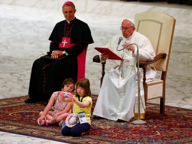 A child takes pictures as she sits in front of Pope Francis during a special audience during a Jubilee for the sick and disabled in Paul VI hall at the Vatican June 11, 2016. (Photo by Tony Gentile/Reuters)