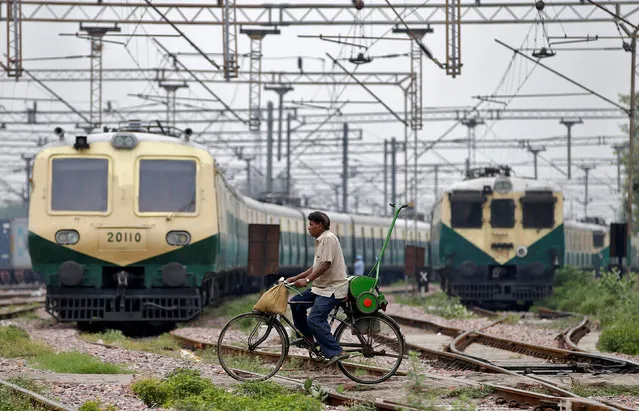 A man rides his bicycle across the railway tracks at Ghaziabad train station in the outskirts of Delhi, June 28, 2017. (Photo by Cathal McNaughton/Reuters)