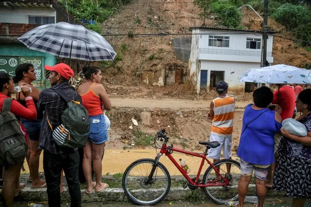 Residents look at a landslide area at the community Jardim Monte Verde, Ibura neighbourhood, in Recife, Pernambuco State, Brazil, on May 29, 2022. Torrential rains in northeastern Brazil have left at least 56 people dead and dozens missing, civil defense officials said Sunday, as rescuers capitalized on a lull in downpours to search for survivors. (Photo by Brenda Alcantara/AFP Photo)