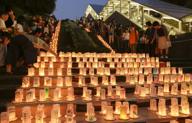 Visitors look at paper lanterns displayed for the Peace Candle Lights at Nagasaki Peace Park in Nagasaki, southwestern Japan, 08 August 2015, the eve of the 70th anniversary of the atomic bombing of the city on 09 August 2015. The atomic bombing of Nagasaki city killed about 74,000 people and injured about 75,000 people of 240,000 population in 1945. (Photo by Kimimasa Mayama/EPA)