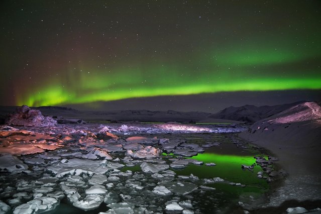 The Northern Lights, also known as the aurora borealis, over a glacier lagoon in Jokulsarlon, Iceland on Friday, December 3, 2021. (Photo by Owen Humphreys/PA Images via Getty Images)