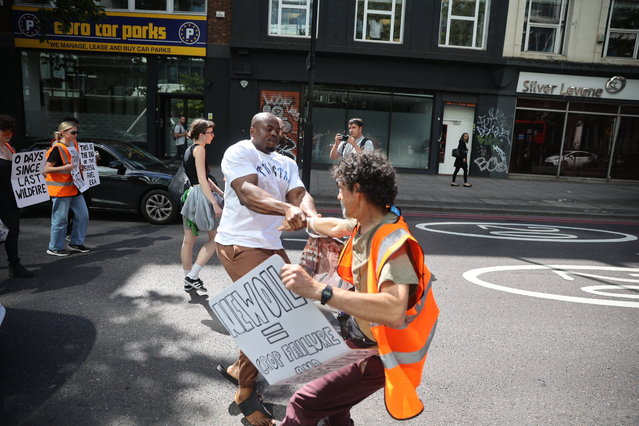 A man confronts activists from Just Stop Oil who block traffic on Marylebone Road in central London on July 17, 2023. Protesters from the group, an offshoot of Extinction Rebellion, have blocked roads, bridges and major events in the capital in order to highlight their demand that the government stop new oil and gas projects. (Photo by Marcin Nowak/London News Pictures)