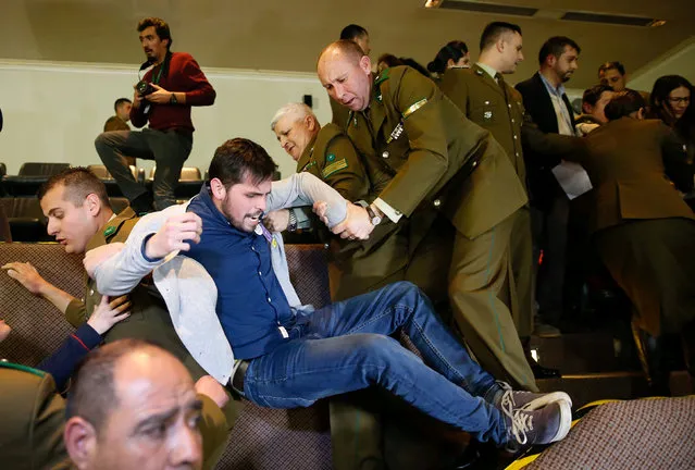 A demonstrator is detained by police officers after shouting slogans against abortion inside the Chilean congress during a session legislating a draft law which seeks to ease the country's strict abortion ban, in Valparaiso, Chile July 18, 2017. (Photo by Rodrigo Garrido/Reuters)