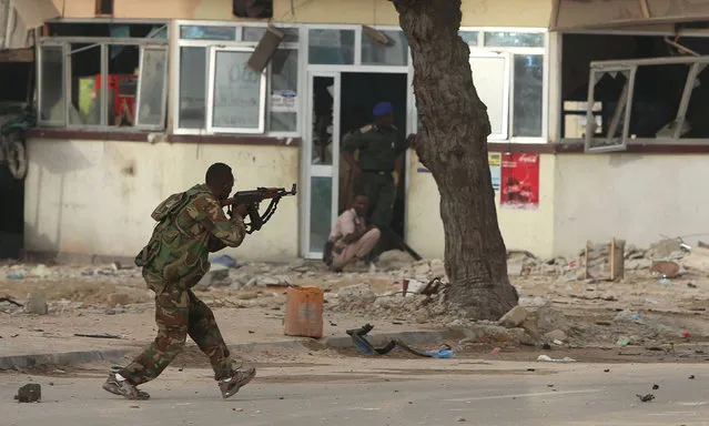 A Somali government soldier runs to take position during gunfire after a suicide bomb attack outside Nasahablood hotel in Somalia's capital Mogadishu, June 25, 2016. (Photo by Feisal Omar/Reuters)