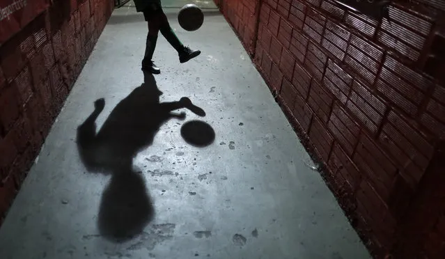 In this November 11, 2016 photo, a child plays with a ball at the youth soccer academy, Club Social Parque, in a working class neighborhood of Buenos Aires, Argentina. Club Social Parque is the same soccer talent factory where international stars like Diego Maradona, Carlos Tevez and Juan Roman Riquelme polished their skills as children. (Photo by Natacha Pisarenko/AP Photo)