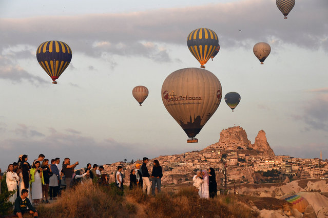 People watch hot air balloons flying over Cappadocia in Nevsehir, Türkiye on May 5, 2024. (Photo by Xinhua News Agency/Rex Features/Shutterstock)