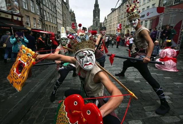 Edinburgh Fringe Festival acts play to the crowds during the first day of the festival on the Royal Mile, on August 1, 2014. (Photo by David Cheskin/PA Wire)