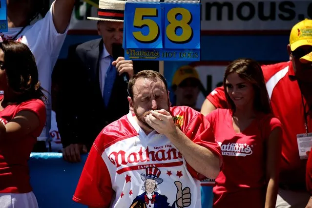 US Champion eater Joey Chestnut eats hot dogs as he participates in Nathan's Famous Fourth of July International Hot-dog eating contest in Coney Island, New York, USA, 4 July 2016. Chestnut went on to win his ninth contest, consuming 70 hotdogs. (Photo by Peter Foley/EPA)
