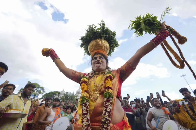 A devotee dances balancing decorated pots, filled with cooked rice as an offering for goddess Kali, during the Bonalu festival in Hyderabad, India, Tuesday, July 19, 2022. Bonalu is a month-long Hindu folk festival of the Telangana region dedicated to Kali, the Hindu goddess of destruction. (Photo by Mahesh Kumar A./AP Photo)