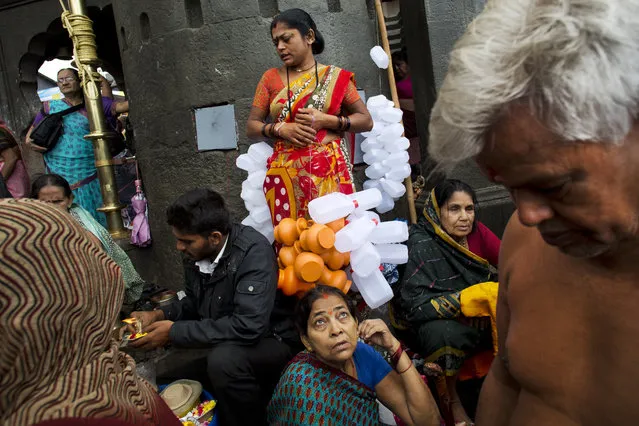 Hindu pilgrims and street vendors gather next to the Godavari River during Kumbh Mela, or Pitcher Festival, celebrations in Nasik, India, Wednesday, August 26, 2015. (Photo by Bernat Armangue/AP Photo)
