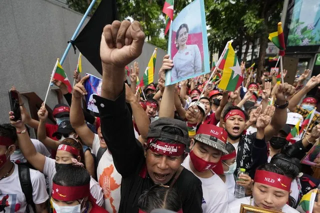 Myanmar nationals living in Thailand with a picture of deposed Myanmar leader Aung San Suu Kyi, seen at center, stage a rally outside Myanmar's embassy in Bangkok, Thailand, Tuesday, July 26, 2022. International outrage over Myanmar’s execution of four political prisoners is intensifying with grassroots protests and strong condemnation from world governments. (Photo by Sakchai Lalit/AP Photo)