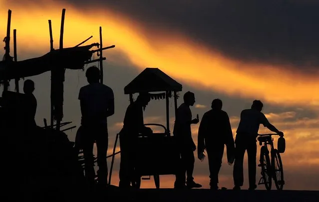 Indian Hindu devotees return home after performing evening prayers at the Sangam, the confluence of rivers Ganga, Yamuna, and mythical Saraswati River in Allahabad on July 29, 2014. (Photo by Sanjay Kanojia/AFP Photo)