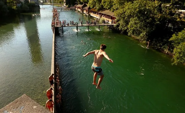 A man jumps from a bridge into the Limmat river during hot temperatures in Zurich, Switzerland July 20, 2016. (Photo by Arnd Wiegmann/Reuters)