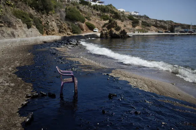 A plastic chair stands on a polluted beach after an oil spill on the island of Salamina, Greece, near Athens, on Tuesday, September 12, 2017. Greece's merchant marine minister says clean-up crews are working to contain the damage caused after the small tanker Agia Zoni II sank off Salamina on Sunday, Sept. 10, with a cargo of 2,200 tons of fuel oil and 370 tons of marine gas oil. (Photo by Petros Giannakouris/AP Photo)