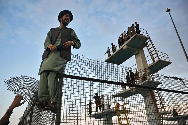 Men gather on diving platforms at the unused swimming pool atop Wazir Akbar Khan Hill in Kabul on August 12, 2022. (Photo by Lillian Suwanrumpha/AFP Photo)
