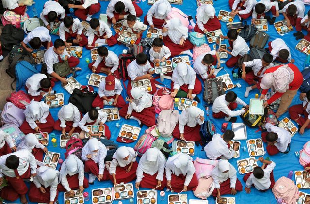 Elementary school students eat free meals at Lengkong 1 elementary school in Tangerang, Indonesia, 06 January 2025. The Indonesian government has officially started the Free Nutritious Meal Program (MBG) with a total of 190 kitchens across 26 provinces serving the community, aiming to make a major milestone in fulfilling national nutrition needs. (Photo by Adi Weda/EPA/EFE)