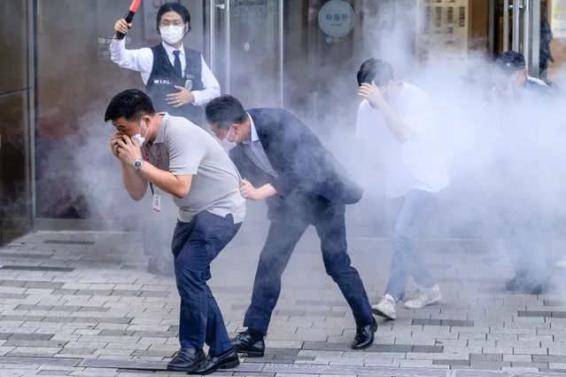 South Korean civilians participate in an anti-terror and anti-chemical terror drill on the sidelines of the joint South Korea-US Ulchi Freedom Shield (UFS) military exercise, outside a shopping mall in Seoul on August 23, 2022. (Photo by Anthony Wallace/AFP Photo)