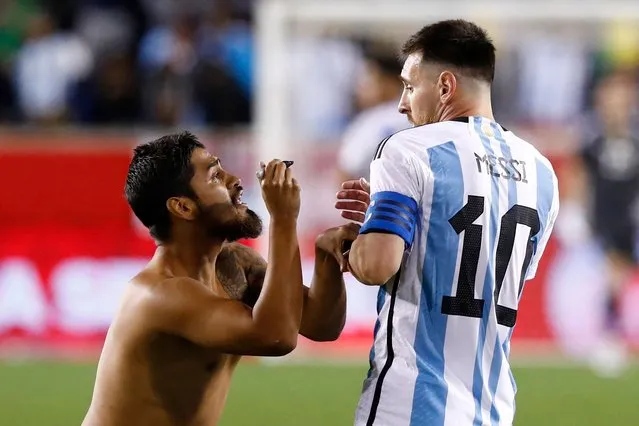 Argentina's Lionel Messi reacts as a fan ran on the pitch to ask for his autograh during the international friendly football match between Argentina and Jamaica at Red Bull Arena in Harrison, New Jersey, on September 27, 2022. (Photo by Andres Kudacki/AFP Photo)