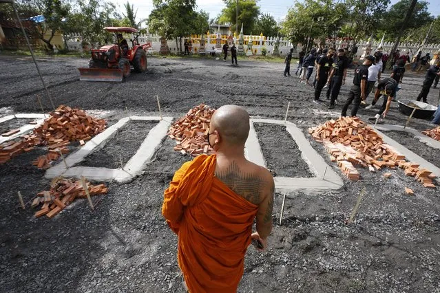 A Thai Buddhist monk looks at the preparation of the site for the mass cremation rite for those who killed in a childcare center mass killing, at a temple in Nong Bua Lamphu province, northeastern Thailand, 10 October 2022. At least 37 people, mostly children, were killed, while another 12 people were injured, after a former policeman committed a mass shooting at a children's care center on 06 October. The gunman subsequently killed his wife and their child, then himself, police said. (Photo by Narong Sangnak/EPA/EFE)