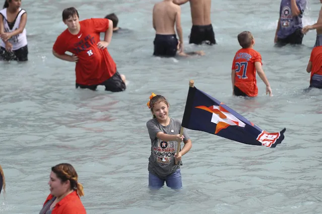 A young fan holds a team flag during the parade and celebration for the baseball World Series champion Houston Astros, Friday, November 3, 2017, in Houston. (Photo by Steve Gonzales/Houston Chronicle via AP Photo)