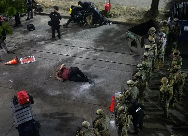 A man lies on the ground grasping a cane after law enforcement deployed chemical agents and blast balls to disperse a protest against racial inequality in the aftermath of the death in Minneapolis police custody of George Floyd, near the Seattle Police department's East Precinct in Seattle, Washington, U.S. June 8, 2020. (Photo by Lindsey Wasson/Reuters)
