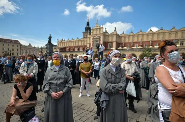 Members of different catholic religious orders seen during a Corpus Christi procession led by Archbishop Marek Jedraszewski in Krakow's Main Market Square. The Feast of Corpus Christi, also known as the Solemnity of the Most Holy Body and Blood of Christ, is a Catholic liturgical solemnity celebrating the Real Presence of the Body and Blood, Soul and Divinity of Jesus Christ in the elements of the Eucharist. On June 11, 2020, in Krakow, Poland. (Photo by Artur Widak/NurPhoto via Getty Images)