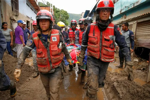Rescue members carry the body of a person that died during a landslide, following floods due to heavy rains, in Las Tejerias, Aragua state, Venezuela on October 9, 2022. (Photo by Leonardo Fernandez Viloria/Reuters)