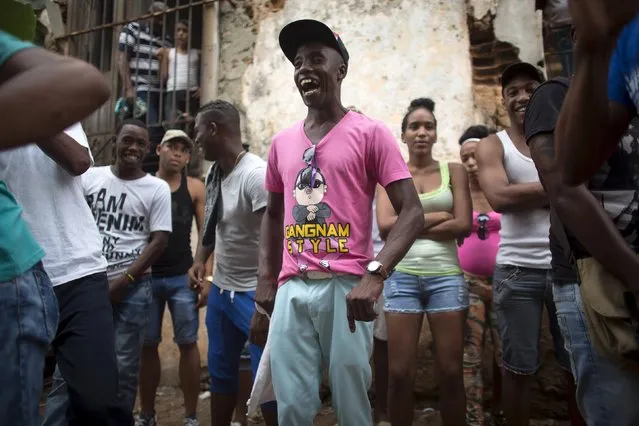 People take part in the party of Yensy Villarreal, 9, (not pictured), in celebration for becoming a Santero after passing a year-long rite of passage in the Afro-Cuban religion Santeria, Havana, July 5, 2015. (Photo by Alexandre Meneghini/Reuters)
