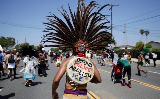 An Aztec dancer participates in a march in honor of Andres Guardado, Sunday, June 21, 2020, in Gardena, Calif. Guardado was shot Thursday after Los Angeles County sheriff's deputies spotted him with a gun in front of a business near Gardena. (Photo by Marcio Jose Sanchez/AP Photo)