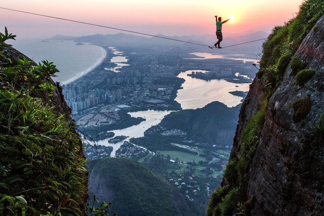 Brave slackliners have been pictured walking the ropes above Rio de Janeiro, Brazil on August 15, 2016, with the half a mile drop showing the city in all its glory. The stunning shots show the daredevils tread across an eighty-two-foot-long high line on Pedra da Gvea mountain with an amazing sunrise illuminating the city landscape behind. The images were captured by Brazilian photographer Rafael Moura (30) and show how lucky fans and athletes are to be in Rio for this Olympics. The lead up to Rio 2016 has been riddled with problems as fears persist over the Zika virus while ten people were recently arrested on suspicion of planning terrorist attacks during the Olympics.Despite this, Rafael felt the city was ready to welcome the world with open arms. (Photo by Rafael Moura/Caters News Agency)