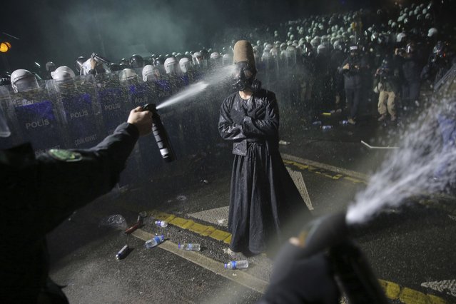 Riot police officers use pepper spray to clear a protester during a protest after Istanbul's Mayor Ekrem Imamoglu was arrested and sent to prison, in Istanbul, Turkey, Sunday, March 23, 2025. (Photo by Huseyin Aldemir/AP Photo)