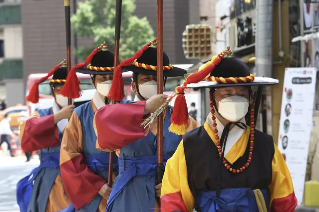 South Korean Imperial guards wearing face masks to help protect against the spread of the new coronavirus move near the Deoksu Palace in Seoul, South Korea, Friday, July 3, 2020. (Photo by Ahn Young-joon/AP Photo)