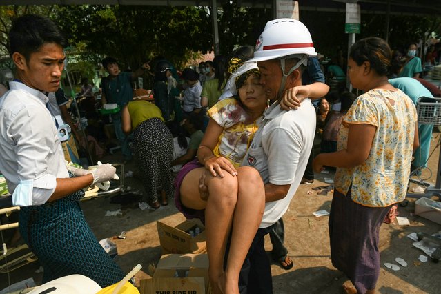 An earthquake survivor is carried as she waits to receive medical attention at a hospital in Naypyidaw on March 28, 2025, after an earthquake in central Myanmar. (Photo by Sai Aung Main/AFP Photo)
