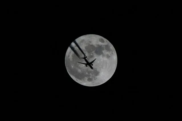 An aircraft flies in front of a full moon in Van, Turkey on December 03, 2017. (Photo by Ozkan Bilgin/Anadolu Agency/Getty Images)