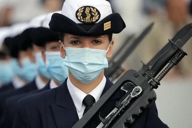 A soldier wears a face mask prior to the Bastille Day parade Tuesday, July 14, 2020 on the Champs Elysees avenue in Paris. France are honoring nurses, ambulance drivers, supermarket cashiers and others on its biggest national holiday Tuesday. Bastille Day's usual grandiose military parade in Paris is being redesigned this year to celebrate heroes of the coronavirus pandemic. (Photo by Christophe Ena/AP Photo)