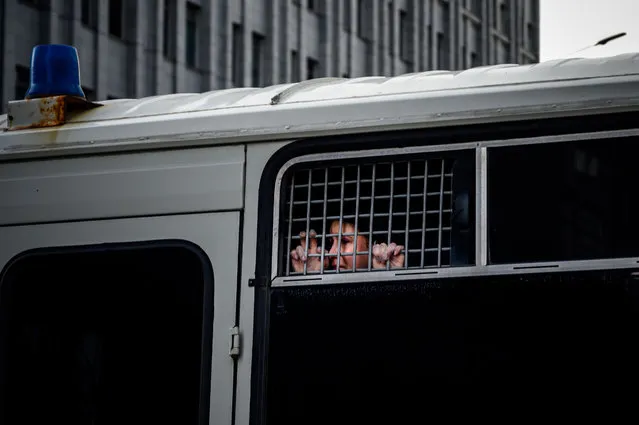 A detained supporter of Ivan Safronov, a former journalist and aide to the head of Russia's space agency Roscosmos, looks out from inside a police bus in central Moscow on July 7, 2020. A high-profile Russian journalist who became an advisor to the head of the space agency was detained on July 7, 2020 on charges of treason for divulging state military secrets, authorities said. (Photo by Dimitar Dilkoff/AFP Photo)