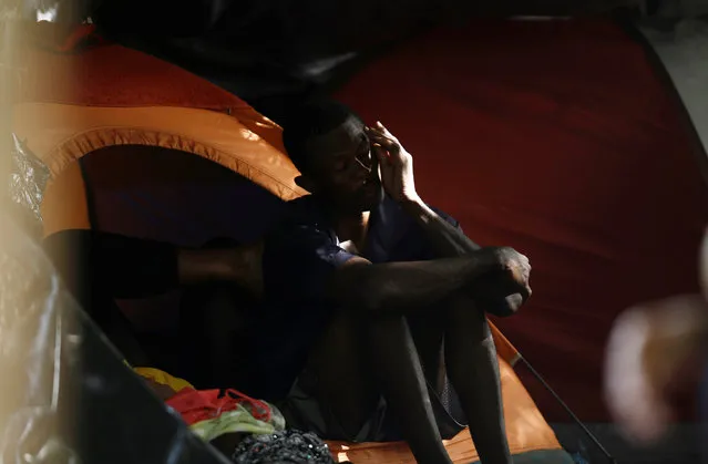 An African migrant stranded in Costa Rica sits outside his camping tent in a makeshift camp at the border between Costa Rica and Nicaragua, in Penas Blancas, Costa Rica, September 8, 2016. (Photo by Juan Carlos Ulate/Reuters)