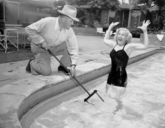 This shocking picture shows Joan Wills screaming as she comes within range of a zone in the water electrified by the “Neptune's Fork” held by Henry T. Burkey in Hollywood, Calif., where he lives, August 22, 1952. Burkey, an electrical engineer, designed the gadget for use by victims of shipwrecks of air crashes over shark-infested waters. The device consists of two electrodes connected to batteries in the waterproof handle. The electrodes create an electrified zone in the water to repel attacking fish. He says the device is shockproof to the user. (Photo by Don Brinn/AP Photo)