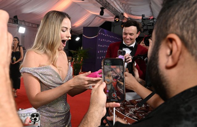 Australian actress Margot Robbie reacts after being given a packet of Tim-Tams on the Red Carpet for the 2024 Australian Academy of Cinema and Television Arts (AACTA) Awards at HOTA in Surfers Paradise, Queensland, Australia 10 February 2024. (Photo by Darren England/EPA)