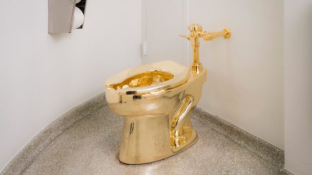 In this undated photo provided by the Solomon R. Guggenheim Museum, an18-karat gold toilet is shown in the museum's 14th floor restroom at the Solomon R. Guggenheim Museum in New York. As part of the museum's “America” exhibit, Italian artist Maurizio Cattelan replaced the standard toilet with the fully functional replica cast in gold. (Photo by Kristopher McKay/Solomon R. Guggenheim Museum via AP Photo)