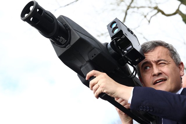 France's Minister for Interior and Overseas Gerald Darmanin holds an anti drone weapon after attending a demonstration of the security system during the Olympic flame's journey, in Beynes, west of Paris, on March 18, 2024. (Photo by Emmanuel Dunand/AFP Photo)